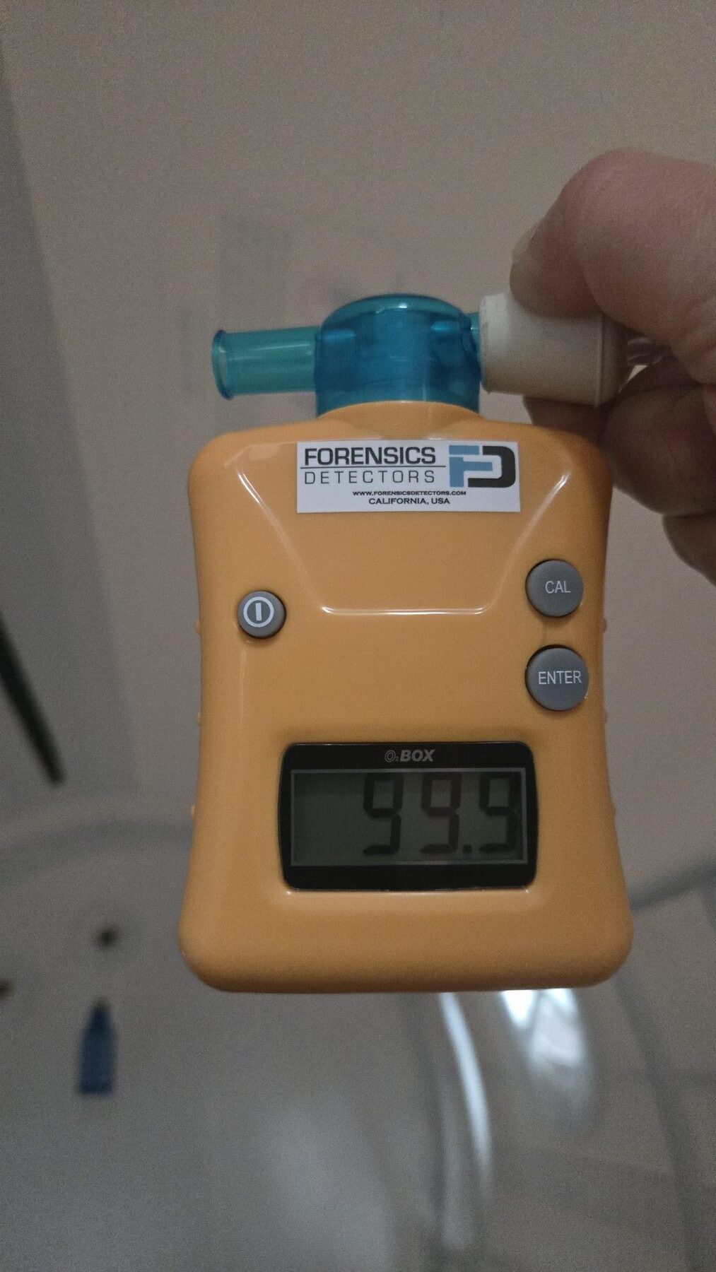 A handheld oxygen analyzer reading 99.9% oxygen concentration from the chamber's mask supply.